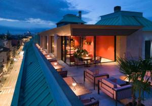 米兰Radisson Collection Hotel, Santa Sofia Milan的大楼内带桌椅的屋顶露台