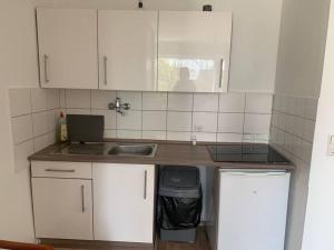 埃森Fantastisches Apartment Essen 1 Zimmer 1-2 Personen:的厨房配有白色橱柜和水槽