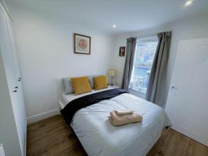 伦敦(ZONE 2) STYLISH 2 BED FLAT IN THE HEART OF LEWISHAM的一间卧室配有一张带黄色枕头的床和一扇窗户