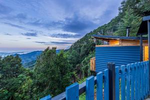RivasTiny House Jaulares的山上房子前面的蓝色围栏