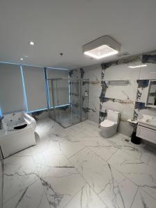 马尼拉City Park Hotel Residences的浴室配有2个盥洗盆、卫生间和淋浴。