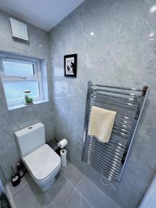 伦敦(ZONE 2) STYLISH 2 BED FLAT IN THE HEART OF LEWISHAM的一间带白色卫生间的浴室和窗户。