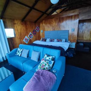 普诺Uros Tikarani hotel的客厅配有蓝色的沙发和床。