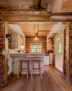 戈尔登莫伯利山林小屋的小木屋内的厨房,配有2张凳子