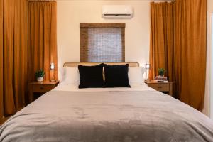 梅德福Oakdale Suites - Master Property的一间卧室配有一张带黑色枕头的大床