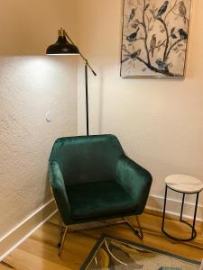梅德福Oakdale Suites - Master Property的灯旁的绿色椅子