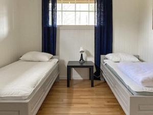 廷瑟Holiday home Tynset的配有桌子和窗户的客房内的两张床