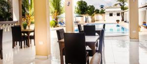 迪亚尼海滩Uhai Vacations的一间带桌椅的餐厅和一个游泳池