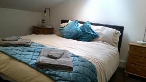 伦敦Stylish West London Getaway Apartment - Shepherd Bush的一张带蓝色枕头的床和毛巾