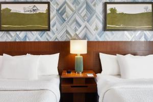 纳什维尔纳什维尔市区/峡谷万豪费尔菲尔德客栈及套房的酒店客房设有两张床和一张带台灯的桌子。