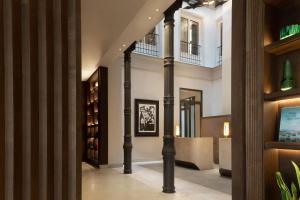 马德里JW Marriott Hotel Madrid的建筑中带柱子和书架的走廊
