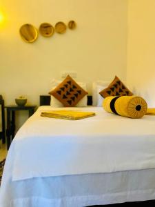 锡吉里亚斯吉利岩石边民宿的一张配有黄色和白色床单的床铺,并提供枕头