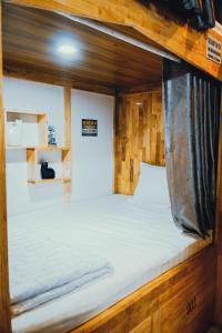 Xóm ÐéThe Dorm Tam Toà的木制客房内的一张大床,