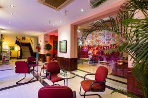 洞海西贡广平酒店的一个带红色椅子的沙龙和候机室
