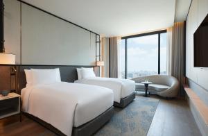 曼谷dusitD2 Samyan Bangkok的酒店客房,设有两张床和一张沙发