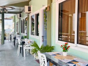 爱妮岛Panari Lodge El Nido的庭院内的餐厅,配有桌椅