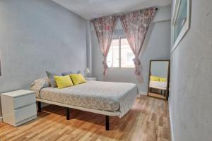 穆尔西亚Lujoso apartamento en el centro de la ciudad的一间卧室配有一张带黄色枕头和镜子的床