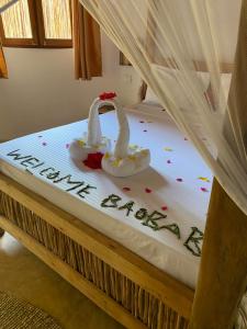 MtendeBaobab Africa Lodge Zanzibar的一张写在上面的幸福新年的床