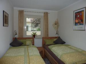 内森尔旺Haus Edelsbergblick的一间卧室设有两张床和窗户。