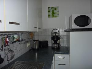 内森尔旺Haus Edelsbergblick的厨房配有白色橱柜和黑色台面