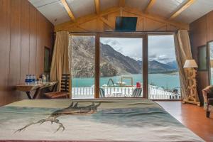罕萨Luxus Hunza Attabad Lake Resort的一张大床,位于带大窗户的房间里