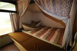 德兰斯克DDR Klappfix "FAMILIENPALAST" direkt am Strand的一张小床,放在带窗户的露营车内