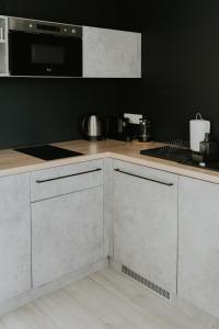 卡托维兹Silesia Apartments的厨房配有白色橱柜和炉灶烤箱。