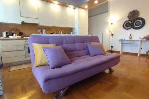 罗马Gastaldi House, EUR Mostacciano, delizioso flat的客厅配有紫色沙发,设有厨房