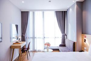 海防IRIS Hotel Hải Phòng的配有一张床、一张书桌和一扇窗户的酒店客房