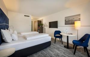 维也纳ARCOTEL Wimberger Wien的酒店客房带一张床、一张桌子和椅子