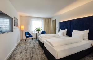 维也纳ARCOTEL Wimberger Wien的酒店客房设有两张床和一张桌子。