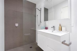 赫斯基森Husky Sol的白色的浴室设有水槽和淋浴。