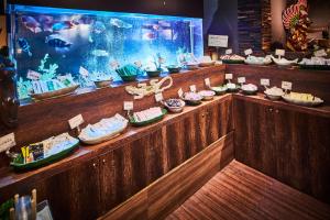东京Hotel Balian Resort Kinshicho的装有许多碗食物和鱼缸的柜台