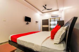 ChinhatVaibhav Laxmi Paradise的一间卧室配有红色和白色枕头的床