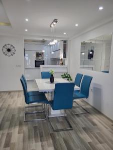 斯特鲁加Chic and Cozy Apartment on the Main Pedestrian Street的一间配备有白色桌子和蓝色椅子的用餐室
