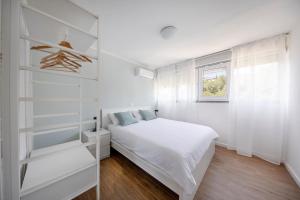 杜布罗夫尼克Apartment Fani with free private parking的白色的卧室设有床和窗户