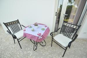 马蒂诺Boat dreams , garden relax的一张桌子、两把椅子和一张桌子,一张桌子上配有粉红色的桌布