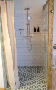 居辛Quartier Romantikum的浴室铺有黑色和白色瓷砖地板,设有淋浴。