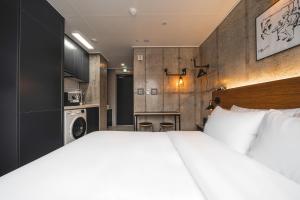 釜山Urbanstay Boutique Nampo BIFF的一间带白色大床的卧室和一间厨房
