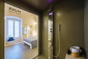 诺奇Murr Luxury Rooms的带淋浴的浴室和客房内的一张床