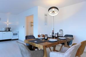 伍珀塔尔Luxus über 2 Etagen mit Balkon in Elberfeld的一间带木桌和椅子的用餐室