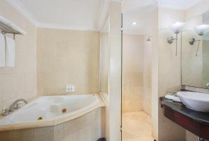 打拉根塔拉坎瑞士贝尔酒店的带浴缸和盥洗盆的浴室