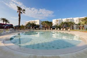 普拉亚登博萨Grand Palladium Palace Ibiza Resort & Spa- All Inclusive的一个带椅子和棕榈树的大型游泳池