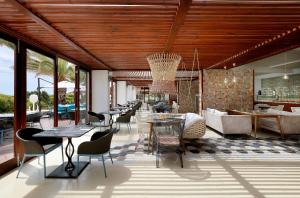 普拉亚登博萨Grand Palladium Palace Ibiza Resort & Spa- All Inclusive的一间带桌椅的餐厅和一间酒吧