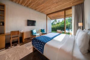 坎古MASMARA Resort Canggu的一间卧室配有一张床、一张书桌和一台电视