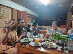 拜县Topp paiway hostel的一群坐在餐桌上吃食物的人