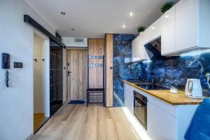 格丁尼亚Apartament Panorama的厨房配有白色橱柜和蓝色大理石墙壁。