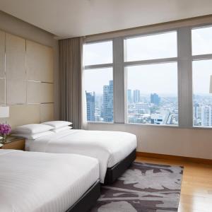 曼谷Marriott Executive Apartments Bangkok, Sukhumvit Thonglor的酒店客房设有两张床和大窗户。