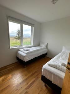 塞尔福斯Brú Country Estate的带窗户的客房内的两张床