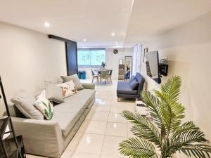 Saint-Aignan-Grand-LieuLe Petit Rocher 30m2- Studio standing tout confort的带沙发和棕榈树的客厅